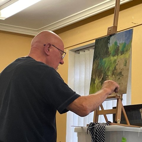 David Briers behind his easel giving a painting demonstrating